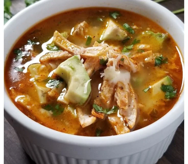 Bowl of amazing chicken tortilla soup garnished with tortilla strips and cilantro