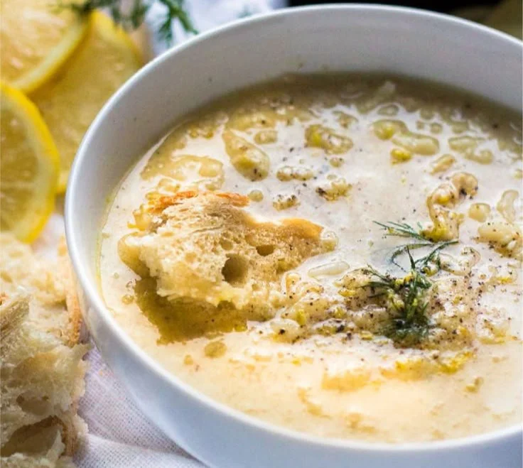 Bowl of Avgolemono Soup, featuring Greek chicken and fresh lemon.