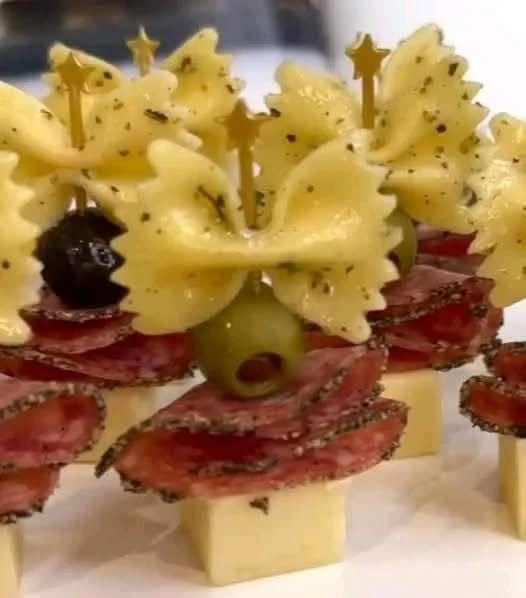 Bow tie pasta appetizers served on a platter with fresh herbs and toppings.