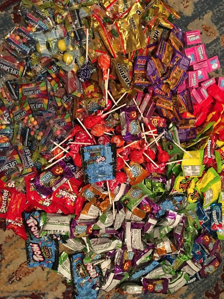 An assortment of colorful candies including gummies, chocolates, and lollipops.