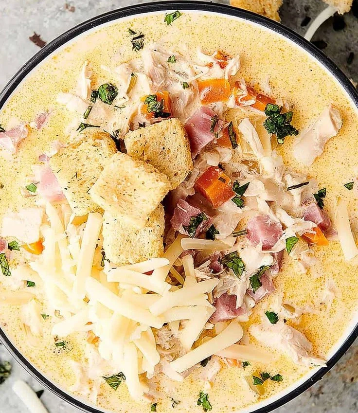 Bowl of creamy Chicken Cordon Bleu soup garnished with herbs