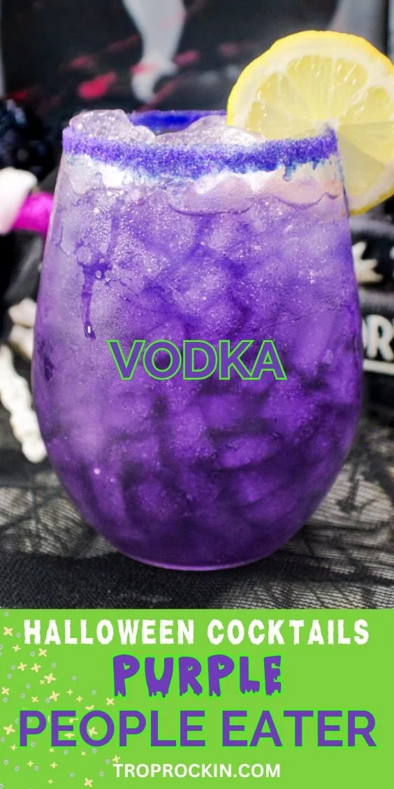 Vibrant Vodka Purple People Eater Halloween cocktail garnished with spooky decorations.