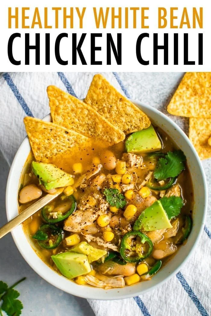 Bowl of healthy white chicken chili topped with cilantro and avocado slices