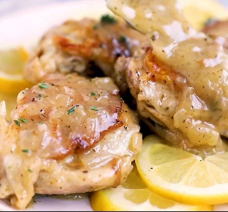 Delicious Instant Pot lemon chicken served on a plate with fresh herbs and lemon slices.