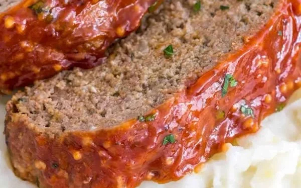 Delicious homemade meatloaf served with mashed potatoes and vegetables.