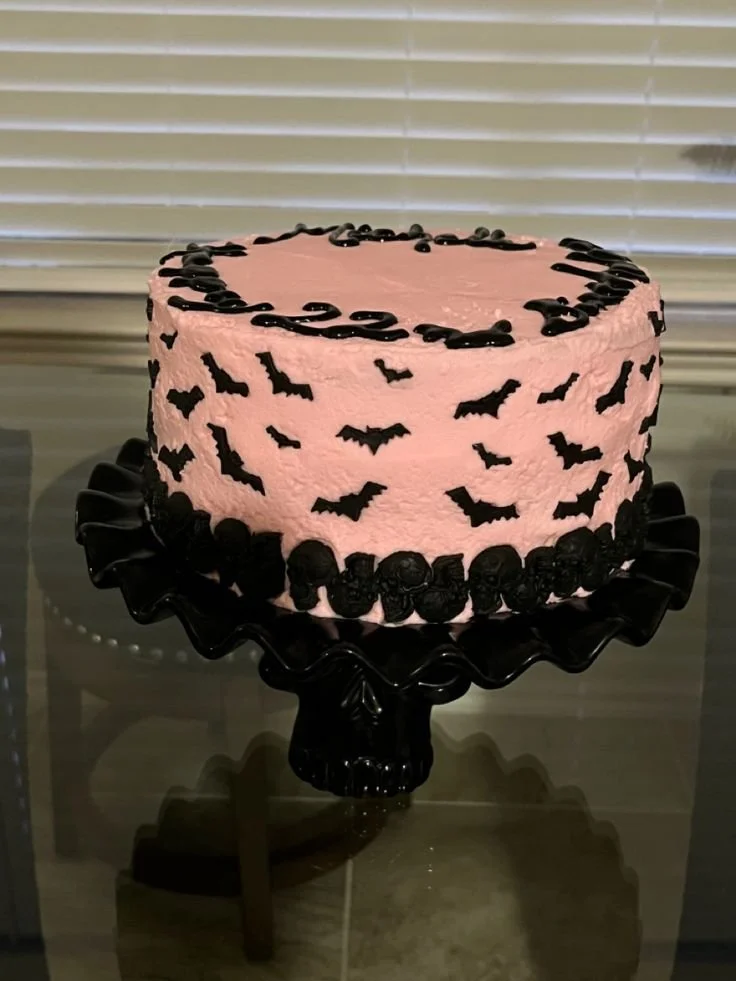 Spooky pink cake decorated with bats and skulls for Halloween celebration