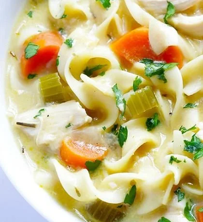Bowl of Skinny Creamy Chicken Noodle Soup garnished with herbs