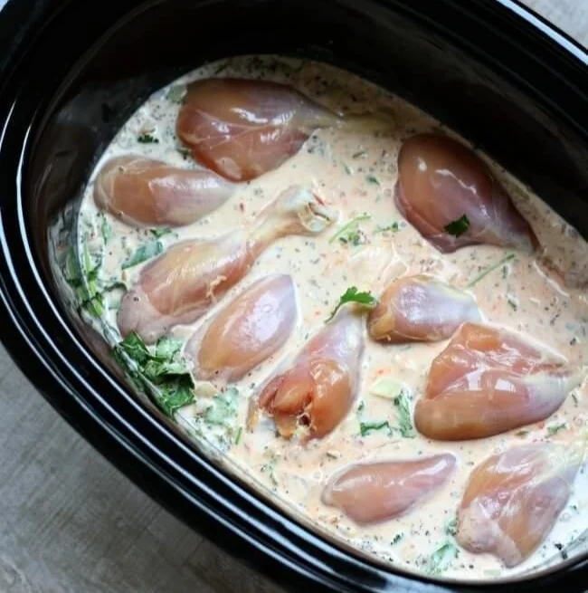 Slow Cooker Coconut Chicken dish garnished with fresh herbs and served on a plate.