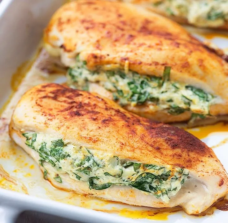 Plated spinach stuffed chicken garnished with herbs and spices