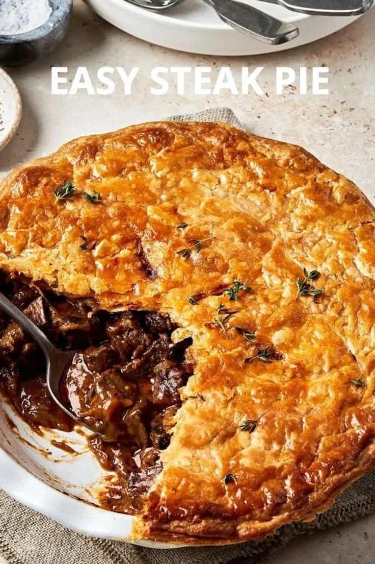 Homemade steak pie served with fresh vegetables and gravy.