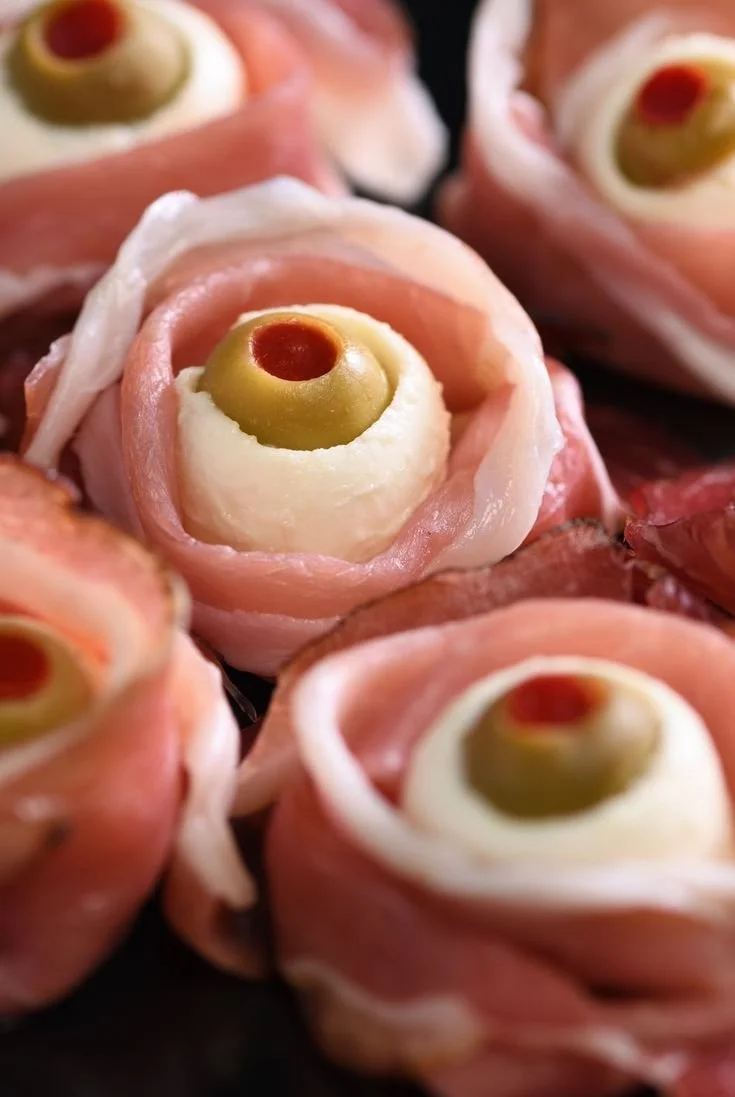 A variety of spooky-themed Halloween appetizers on a festive table.