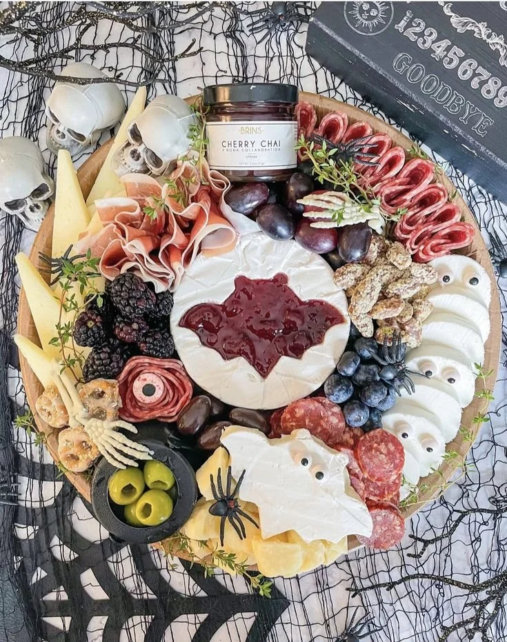 Halloween charcuterie board featuring bat shapes and vampire-themed snacks.