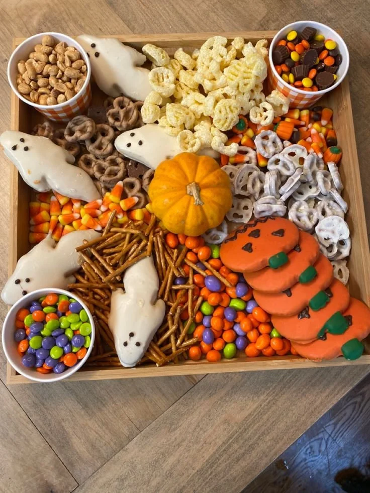 Spooky Halloween charcuterie board with themed snacks and decorations.