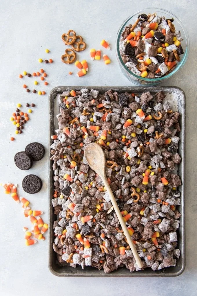 A festive bowl of Halloween Chex Mix Muddy Buddies with candies and sprinkles