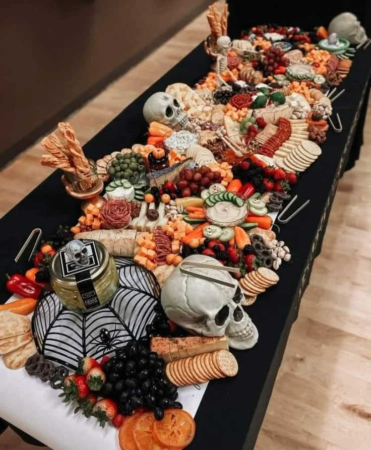 Halloween food and decorations on a long table for a festive buffet