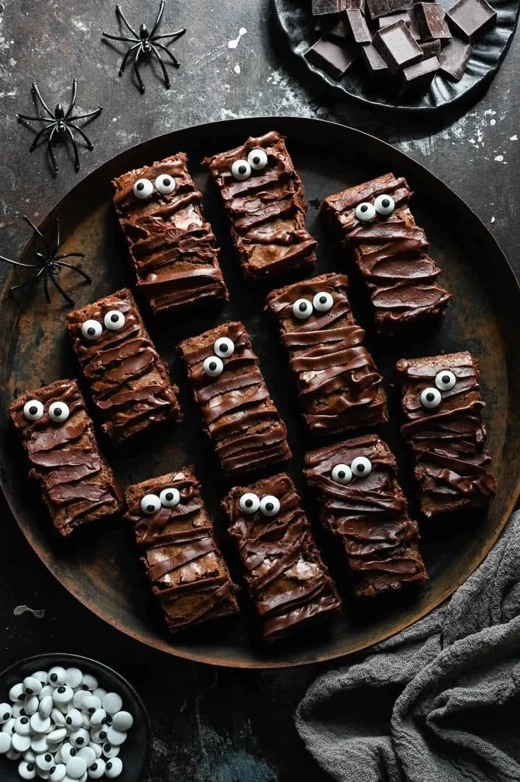 Delicious Halloween mummy brownies decorated for a spooky dessert bar.
