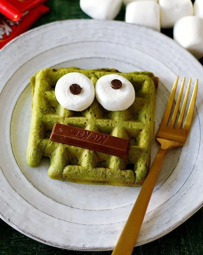 Delicious Matcha Monster Waffles topped with fresh fruits and syrup.
