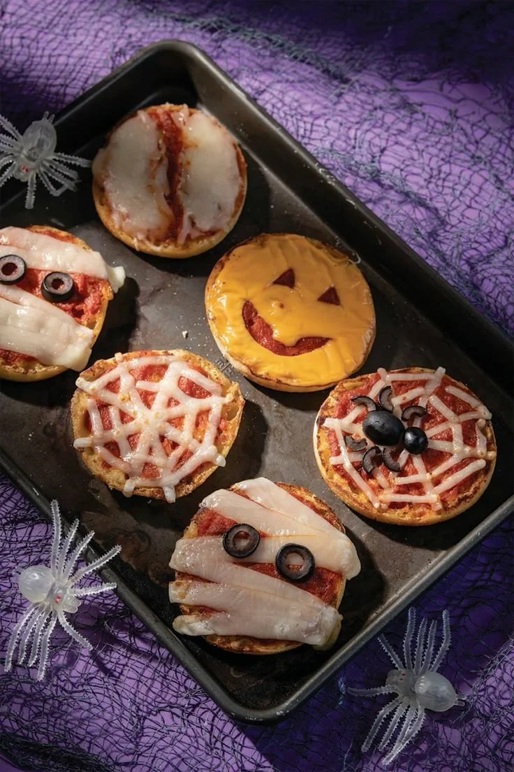 Colorful mini Halloween pizzas shaped like ghosts and pumpkins