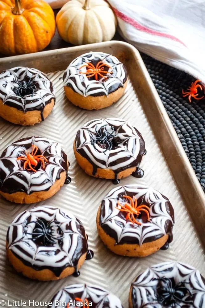 Halloween-themed spider web donuts with chocolate icing and spider decorations
